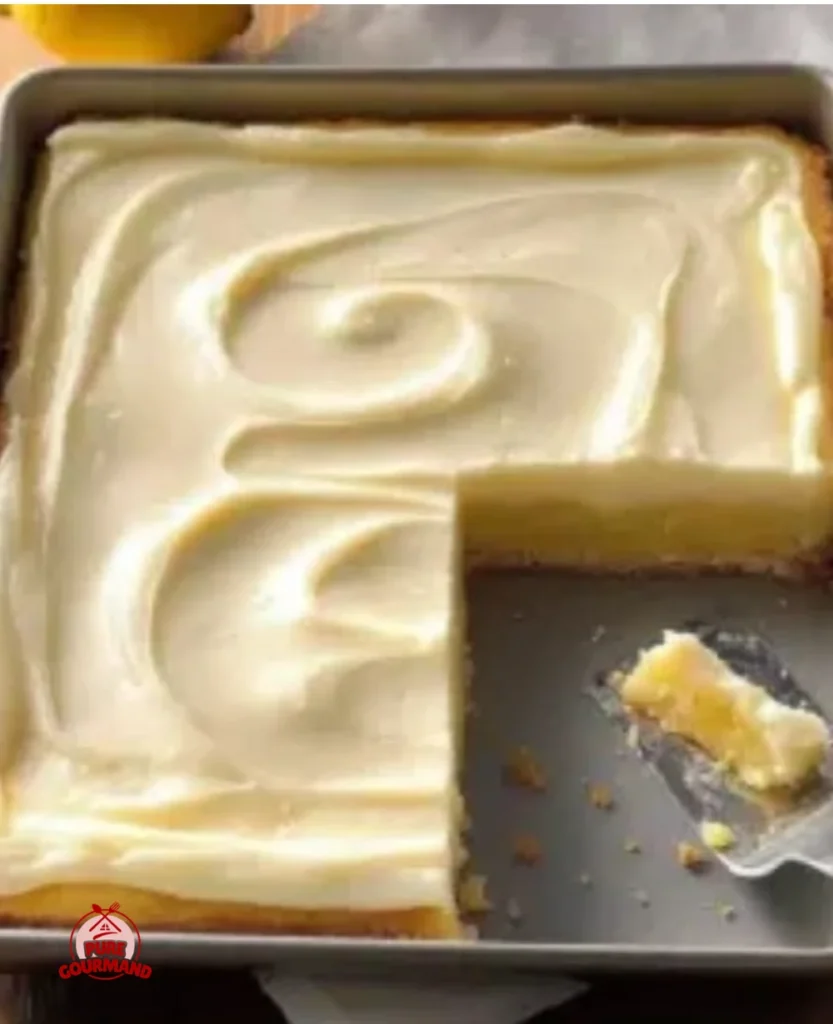 Delicious bright lemon bars topped with cream cheese frosting on a dessert plate