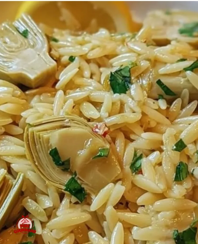 Bowl of Lemon Artichoke Orzo garnished with fresh herbs