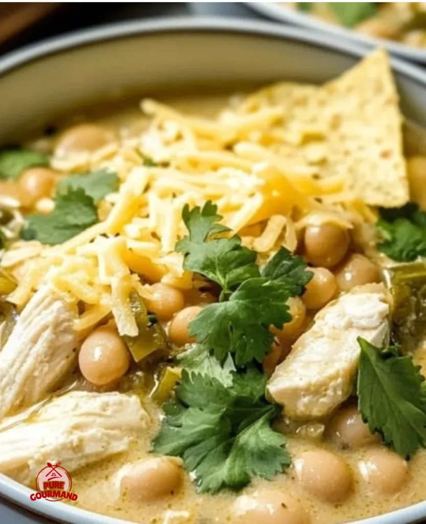 A bowl of creamy white chicken chili topped with fresh cilantro and lime.