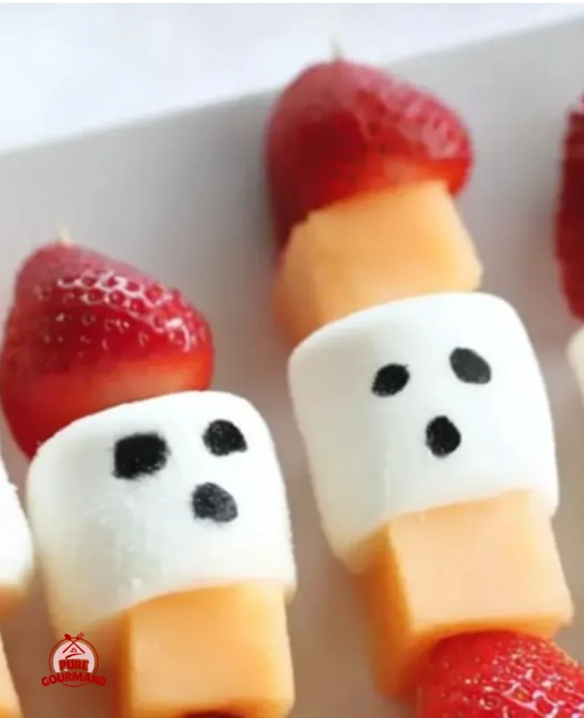 Colorful Ghost Fruit Kabobs served on skewers for Halloween festivities