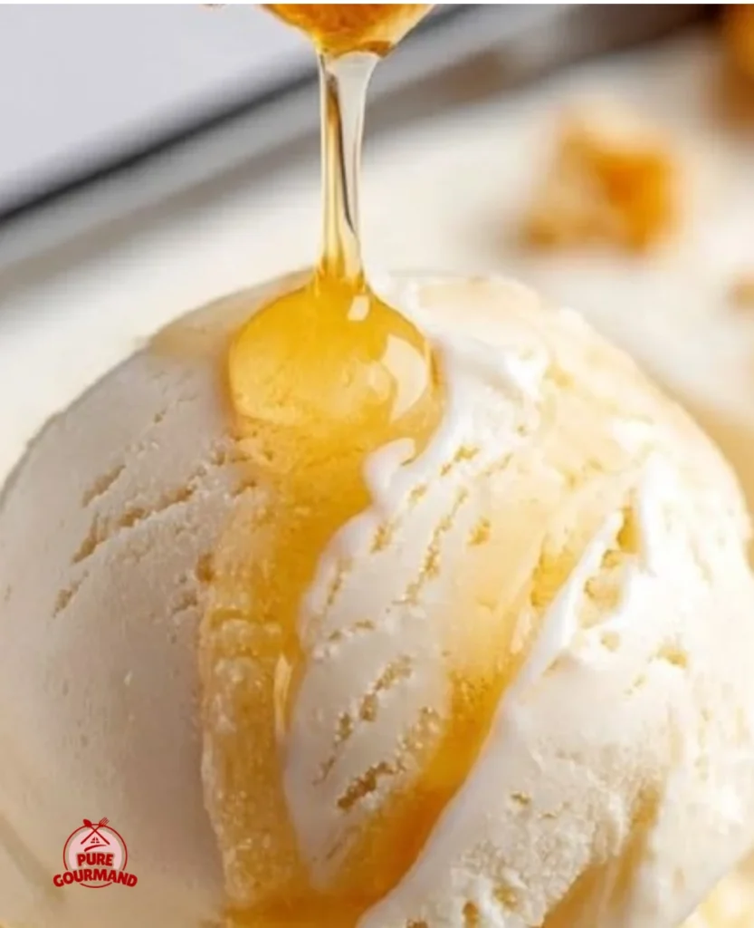 A bowl of homemade honey ice cream with a drizzle of honey on top.