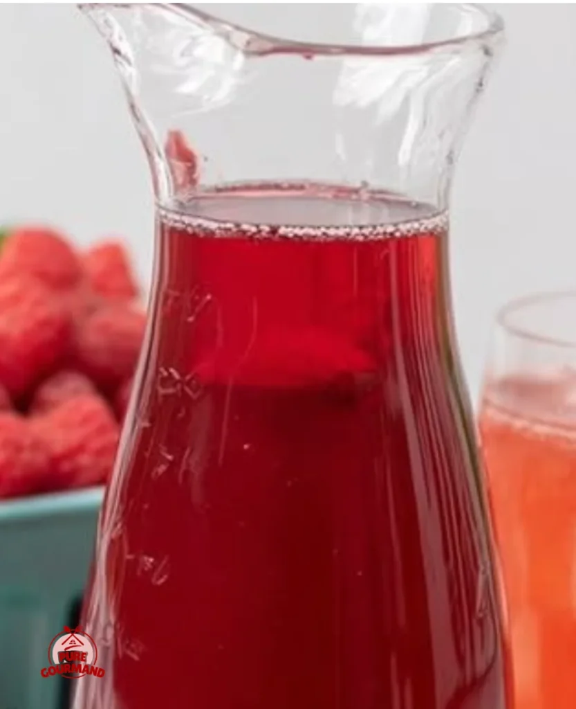 Bottle of Raspberry Simple Syrup with vibrant red color and fresh raspberries