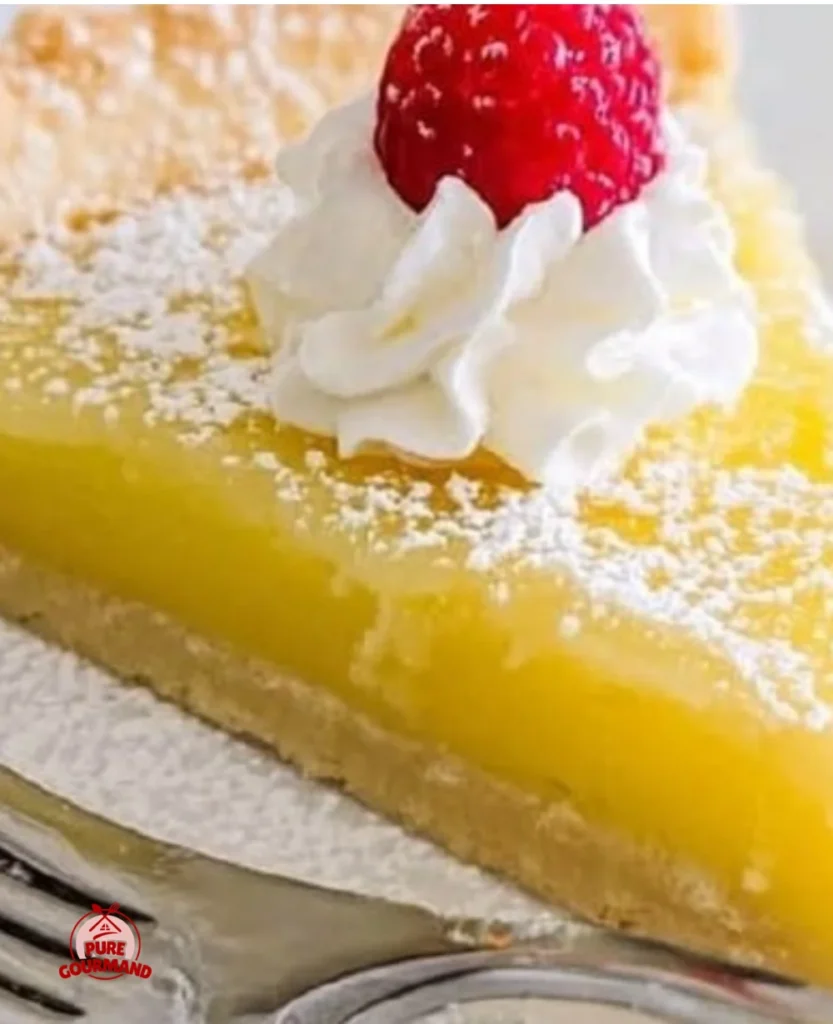 Delicious sunlit lemon tart slice topped with lemon zest and fresh berries.