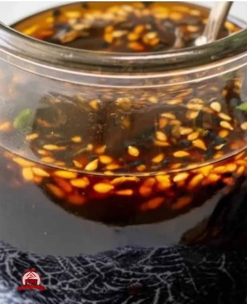 Delicious homemade teriyaki sauce in a glass jar on a wooden table.