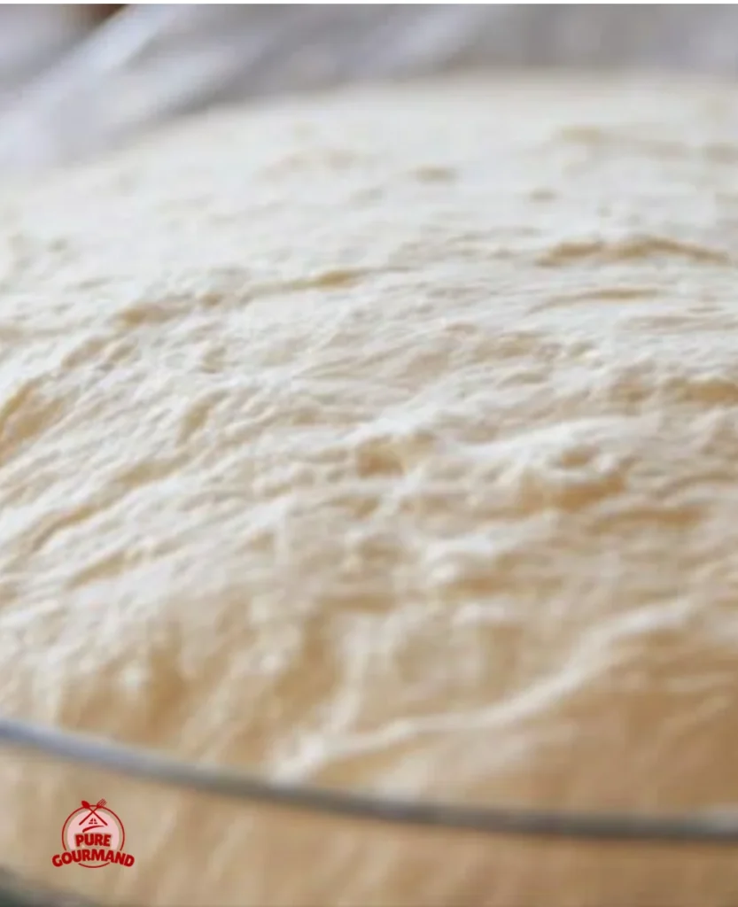 Homemade pizza dough preparation in a cozy kitchen setting.