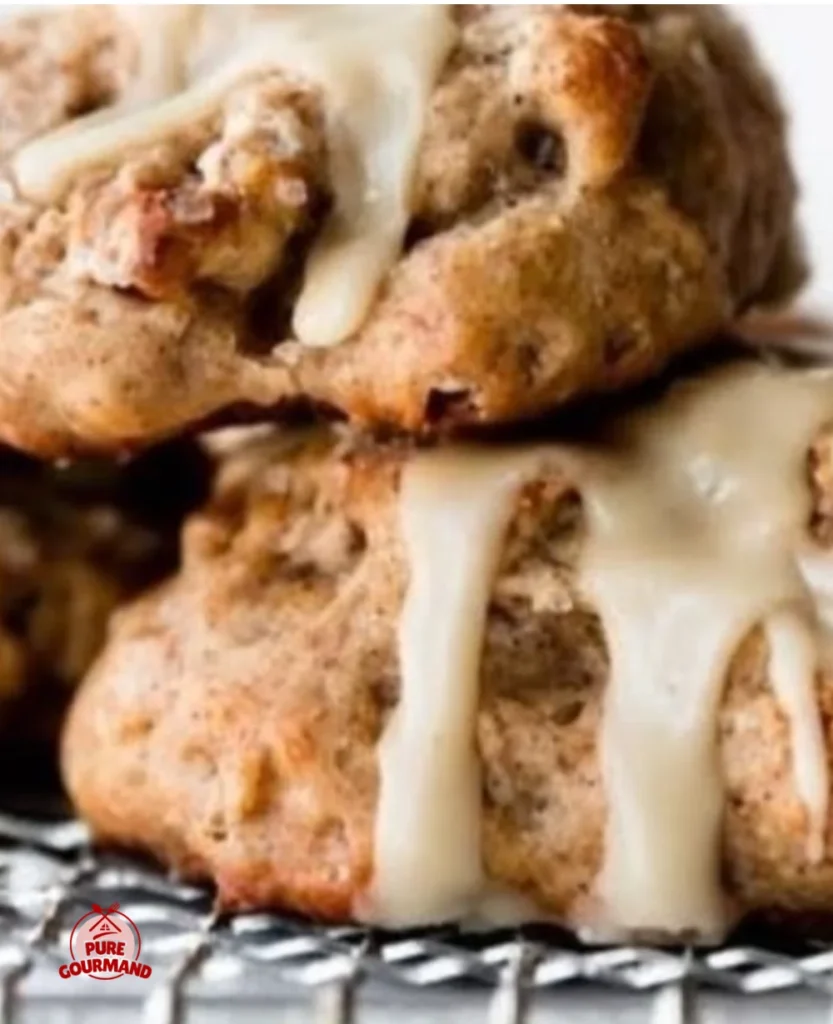 Delicious banana nut scones topped with sweet maple icing on a wooden table.