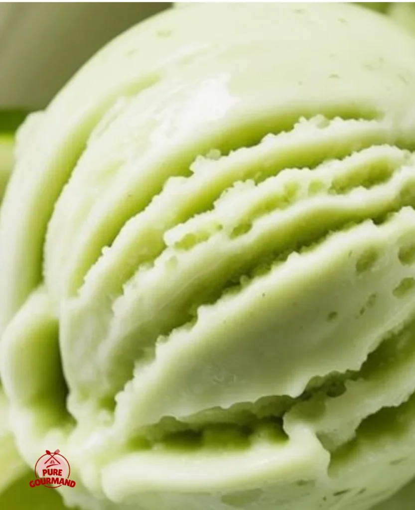 Cucumber Lime Sorbet served in a bowl with fresh cucumber slices and lime wedges.