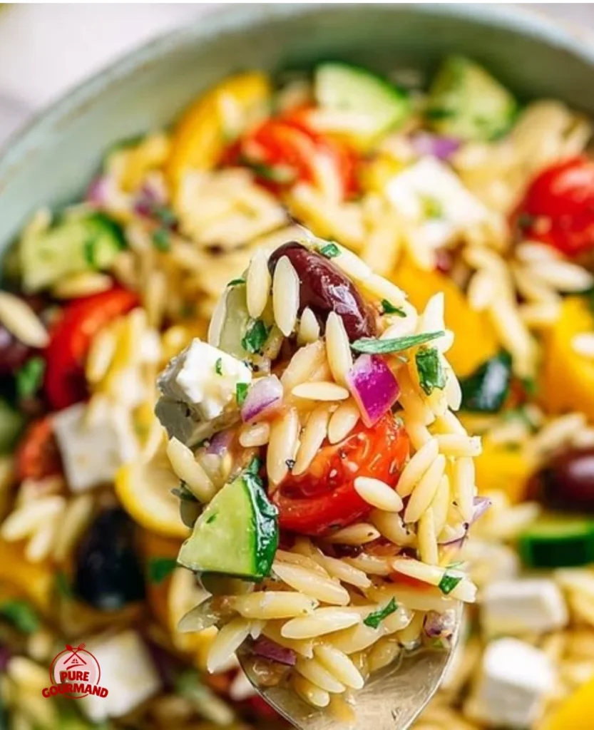 Fresh vegetarian Greek pasta salad with orzo, vegetables, and dressing.