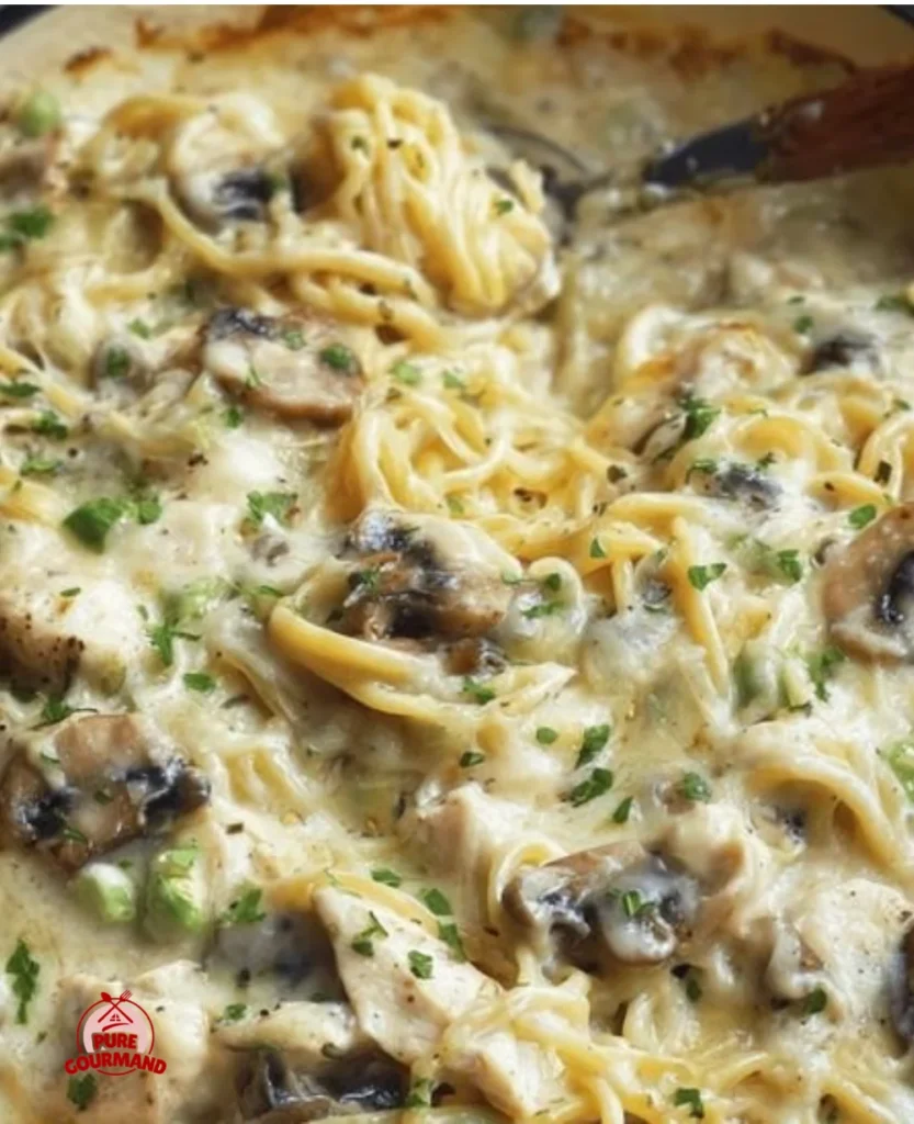 Bowl of creamy chicken tetrazzini topped with herbs and cheese