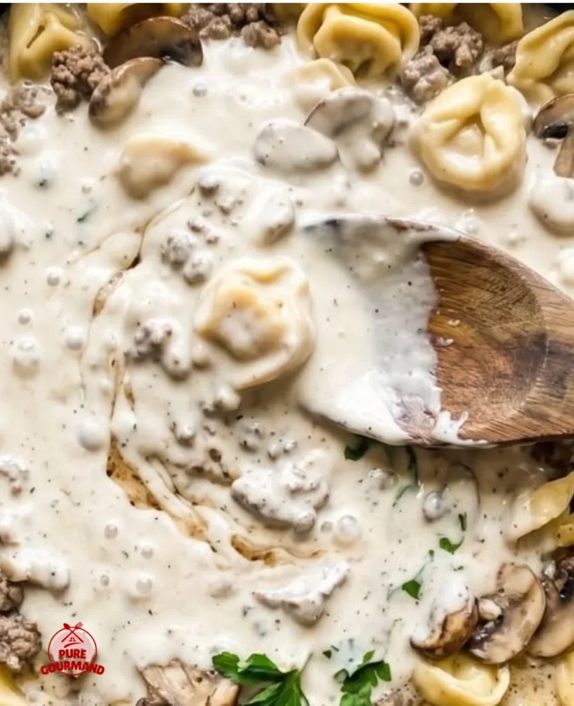 Creamy tortellini stroganoff served in a bowl with fresh herbs