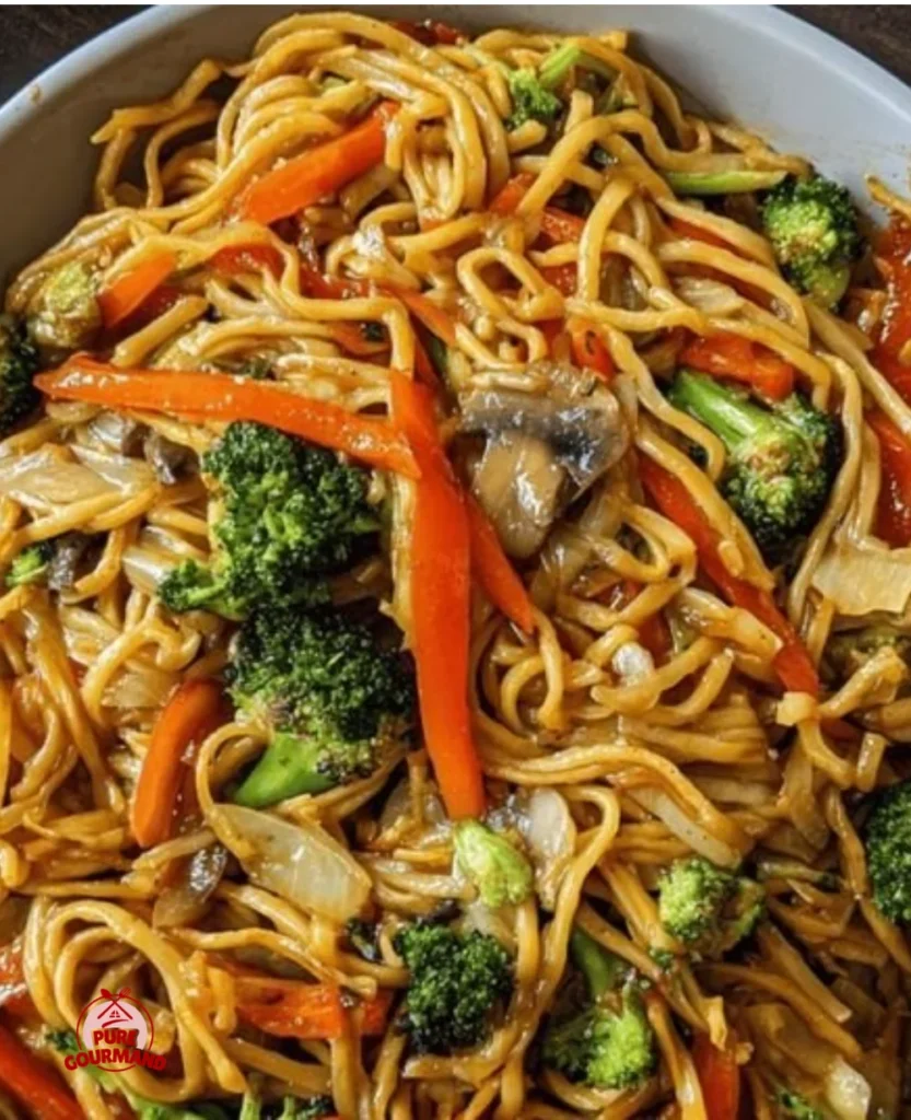 A bowl of easy vegetable lo mein topped with fresh vegetables and herbs.