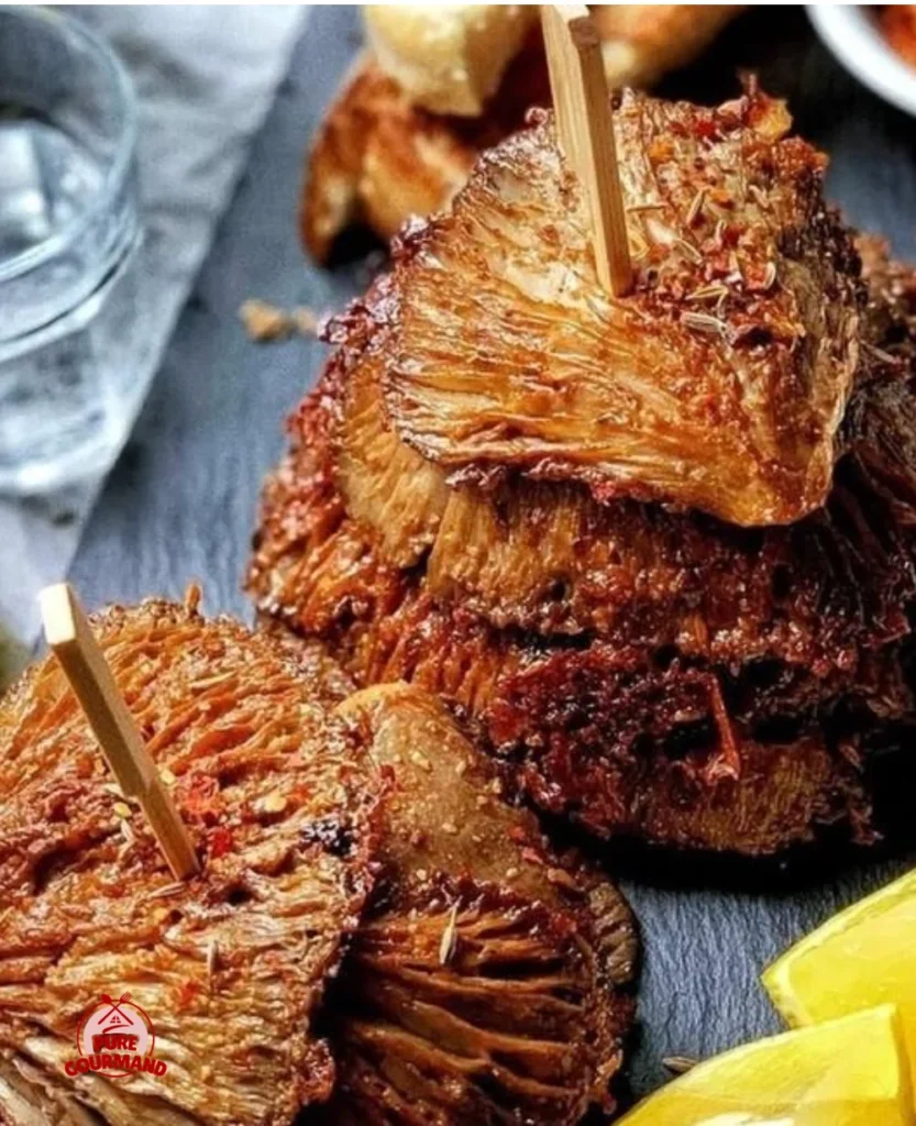 Bowl of golden roasted mushrooms garnished with herbs and spices