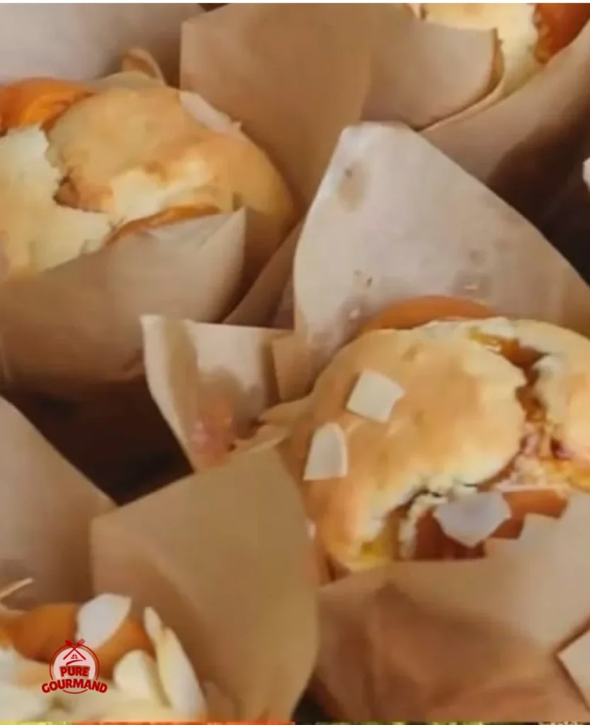 Freshly baked herbal apricot muffins topped with herbs and apricot pieces
