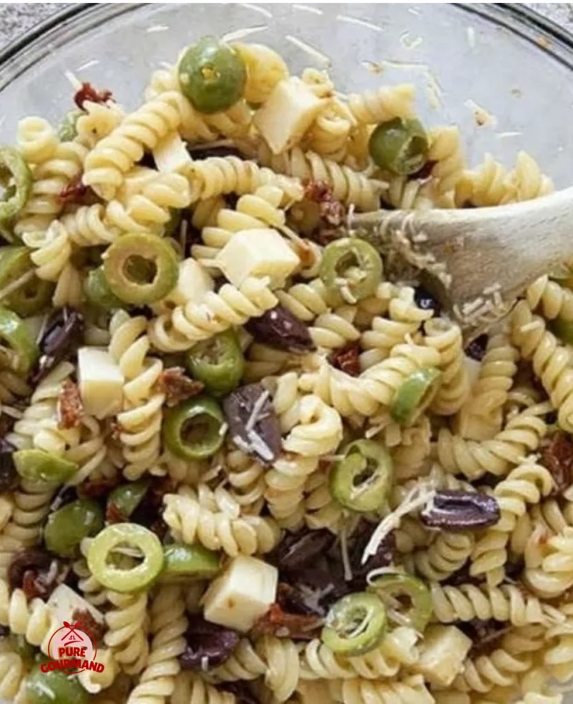 Italian pasta salad with olives, colorful vegetables, and dressing in a bowl