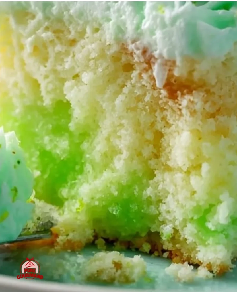 Moist Key Lime Jello Poke Cake topped with whipped cream and lime zest