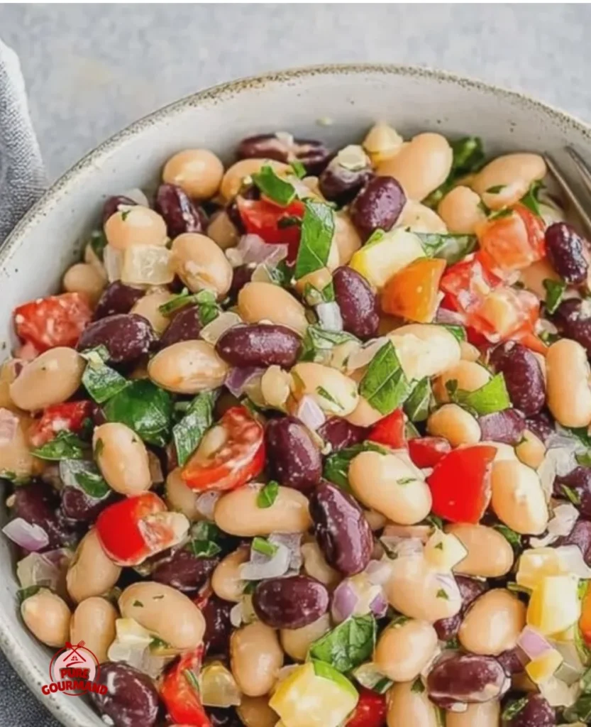 Lemon Basil Three Bean Salad in a colorful bowl garnished with fresh herbs.