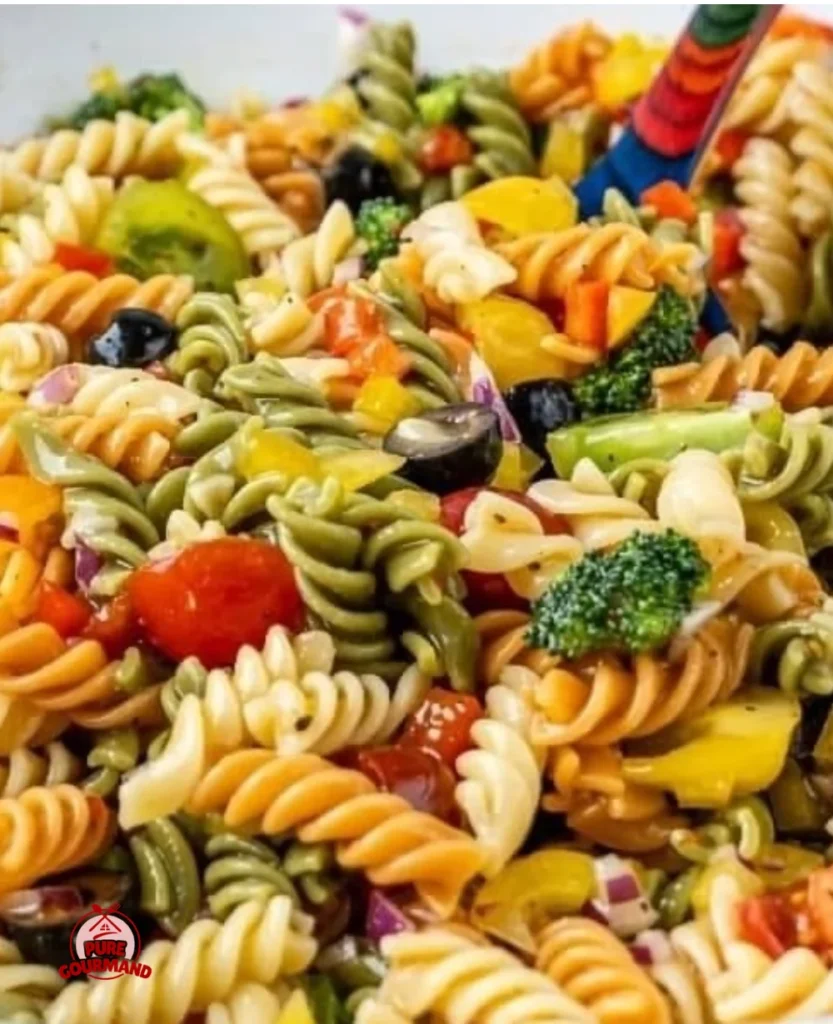 A colorful bowl of fresh pasta salad with vegetables and dressing