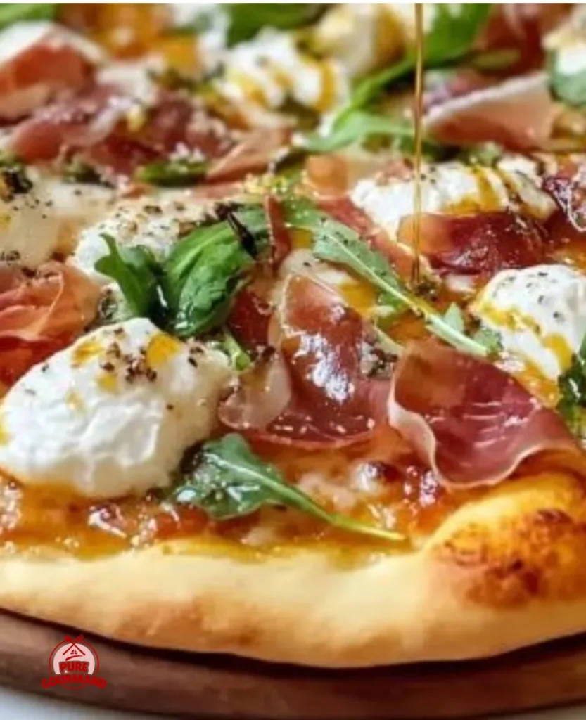 Prosciutto and honey burrata pizza topped with fresh herbs and drizzled with honey.