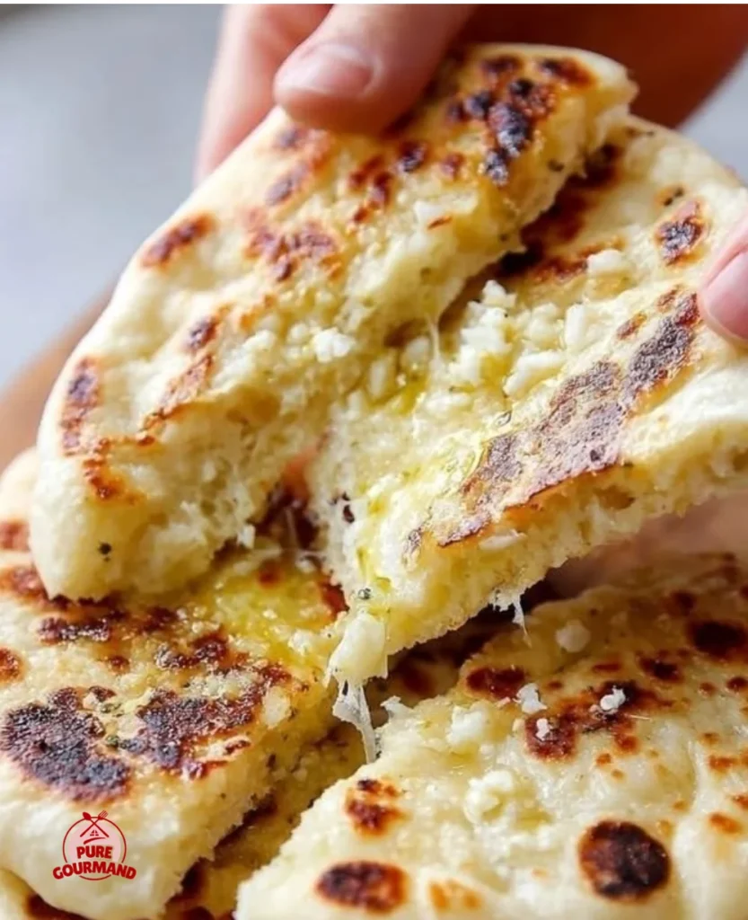 Soft and tender garlic naan flatbread, fresh out of the oven, topped with garlic.